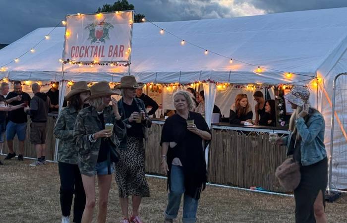 Festival cocktail bar lit up with festoon lights at dusk