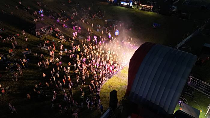 Aerial view of a festival crowd in front of a lit stage